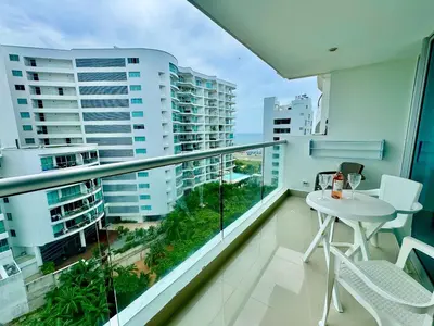 a balcony with a white table and chairs and buildings at Apartamento 1 dormitorio Morros. Vista Mar y Salida Playa in Cartagena de Indias