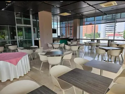 a restaurant with tables and chairs and windows at Apartamento en el Hotel Estelar in Barranquilla