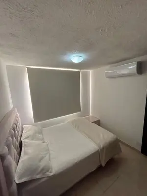 a small bedroom with a bed with a light on it at Comfortable and Relaxing Apartment in Barranquilla