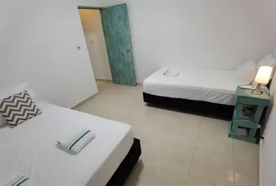 a hotel room with two beds and a mirror at Apartamentos Santori in Cartagena de Indias