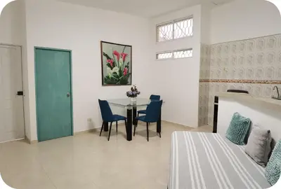 a room with a table and chairs and a bed at Apartamentos Santori in Cartagena de Indias