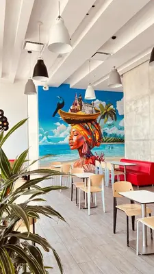 a restaurant with a mural of a woman with a boat at ibis Cartagena Marbella in Cartagena de Indias