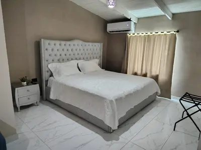 a bedroom with a white bed and a window at Laureles del parque loft in Barranquilla