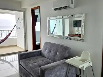 a living room with a couch and a mirror at Oceanfront apartment in Cartagena in Cartagena de Indias