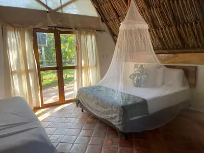 a bedroom with a bed with a mosquito net at Casa Arrecife San Bernardo del Viento in San Bernardo del Viento