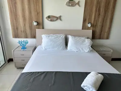 a bedroom with a large bed with white sheets and pillows at Morros la boquilla in Cartagena de Indias