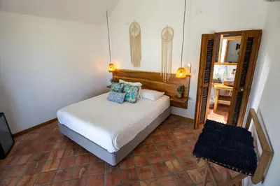 a bedroom with a white bed with blue pillows at Casa Origen Boutique en San Bernardo del Viento in San Bernardo del Viento