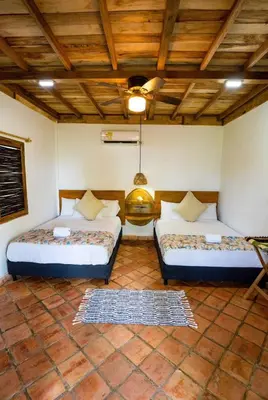 a room with two beds and a wooden ceiling at Casa Origen Boutique en San Bernardo del Viento in San Bernardo del Viento