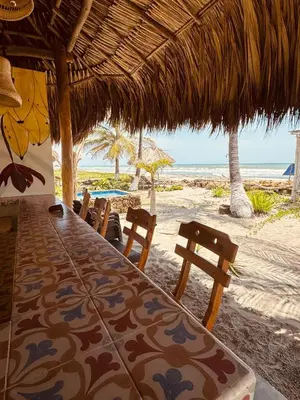 a table and chairs on a beach with the ocean at Casa Origen Boutique en San Bernardo del Viento in San Bernardo del Viento