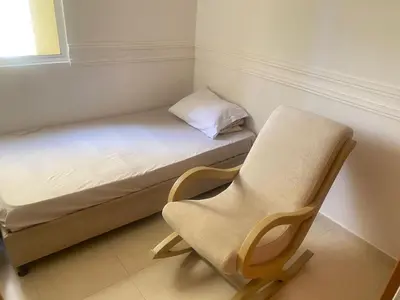 a small bed and a chair in a room at Habitación en Villa Carolina con aire in Barranquilla