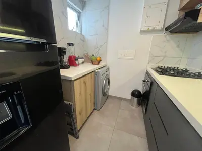 a small kitchen with a stove and a dishwasher at PISO 19 Mirador Oasis Costero in Cartagena de Indias