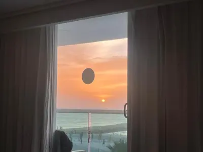 a window with a view of the ocean and the sunset at PISO 19 Mirador Oasis Costero in Cartagena de Indias