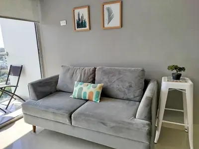 a gray couch in a living room with a side table at PISO 19 Mirador Oasis Costero in Cartagena de Indias