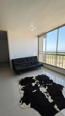 a living room with a black couch and a rug at Apartamento con Vista espectacular en Barranquilla in Barranquilla