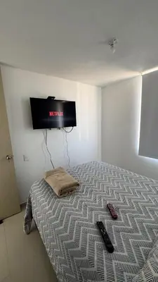 a bedroom with a bed with a television on the wall at Apartamento con Vista espectacular en Barranquilla in Barranquilla