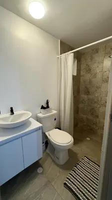 a bathroom with a white toilet and a sink at Apartamento con Vista espectacular en Barranquilla in Barranquilla
