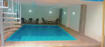 a swimming pool in the middle of a room with chairs at Safariplaya in Cartagena de Indias