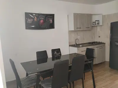 a kitchen with a table and chairs and a refrigerator at Safariplaya in Cartagena de Indias
