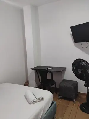 a bedroom with a bed and a desk with a television at Safariplaya in Cartagena de Indias