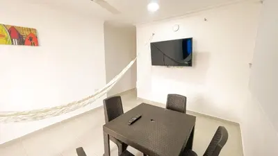 a dining room with a table and a tv on a wall at Apartamento Coveñas in Coveñas