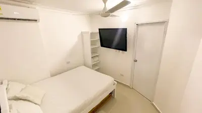 a small room with a bed and a flat screen tv at Apartamento Coveñas in Coveñas