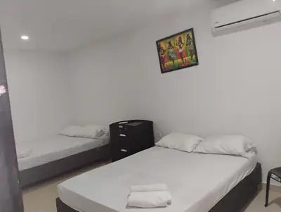 a room with two beds and a picture on the wall at Safarihostal in Cartagena de Indias