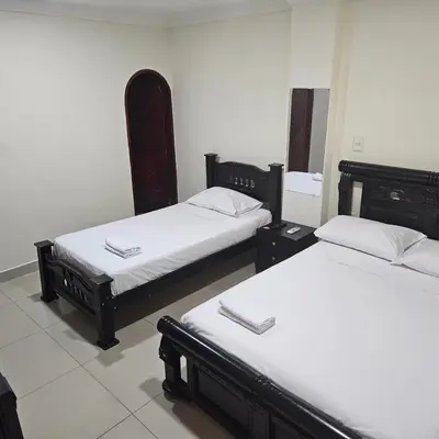 a room with two beds with white sheets at Hotel Barranquilla Inn in Barranquilla