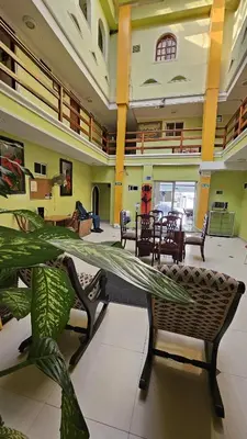 a living room with chairs and a table and a plant at Hotel Barranquilla Inn in Barranquilla