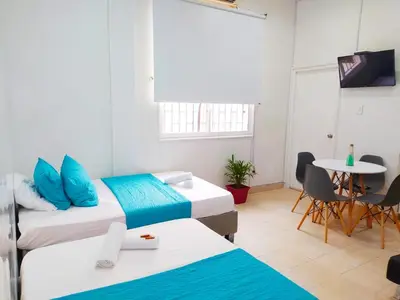 a room with two beds and a table and a tv at Apartamento centro Histórico -303 in Cartagena de Indias