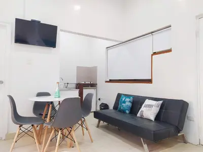 a living room with a black couch and a table at Apartamento centro Histórico -303 in Cartagena de Indias