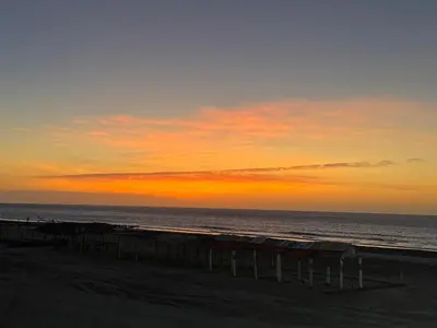 a sunset on the beach with the ocean in the background at Apartamentos el mochilero frente al mar piso 2 apto 3 in Cartagena de Indias
