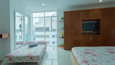 a bedroom with a bed and a tv and a large window at Apartamento Vista Mar 1604 in Cartagena de Indias