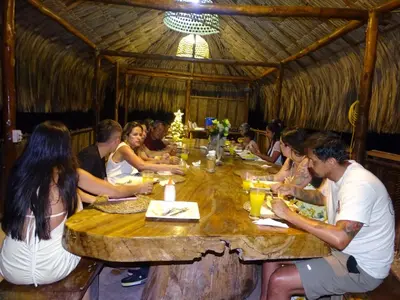 a group of people sitting around a large wooden table at Tintipán Glamping in Tintipan Island
