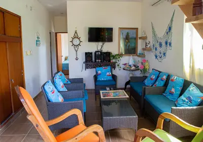 a living room with blue couches and a table at Alojamiento Familiar #2 - La mejor playa y mar in Puerto Viejo