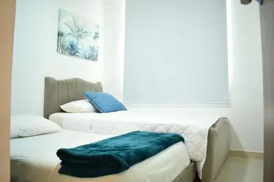two beds in a room with a green blanket on them at Luxury apartment with pool in Barranquilla