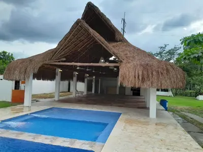 a resort with a thatched roof and a swimming pool at Casa Campestre Rancho 75 Eco Park in Arjona