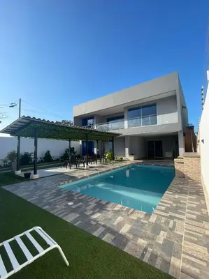 a house with a swimming pool in front of it at Villa Matthew - Villa de Lujo con Piscina Privada y BBQ, Cerca al Mar in Juan de Acosta