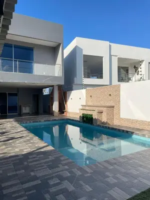 a swimming pool in front of a house at Villa Matthew - Villa de Lujo con Piscina Privada y BBQ, Cerca al Mar in Juan de Acosta