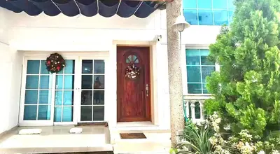 a white house with a red door and a tree at Luxury House Perfect Location in Cartagena de Indias
