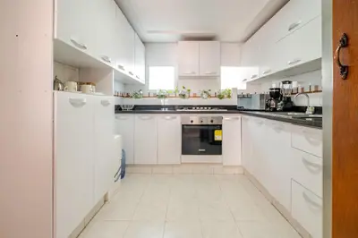 a white kitchen with white cabinets and appliances at Luxury House Perfect Location in Cartagena de Indias