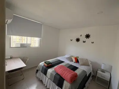 a bedroom with a bed with a red pillow on it at Luxury apartment - Barranquilla 10 minutes to Buenavista in Barranquilla