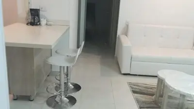 a kitchen with a stool and a table and a chair at Luxury apartment - Barranquilla 10 minutes to Buenavista in Barranquilla