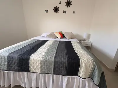 a bedroom with a bed with a black and white blanket at Luxury apartment - Barranquilla 10 minutes to Buenavista in Barranquilla