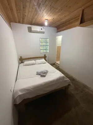 a bedroom with a bed in a white room at Espectacular cabaña frente al mar in Paso Nuevo