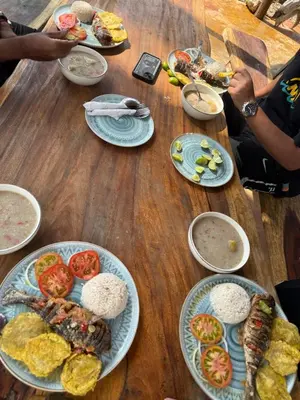 a wooden table with plates of food on it at Espectacular cabaña frente al mar in Paso Nuevo