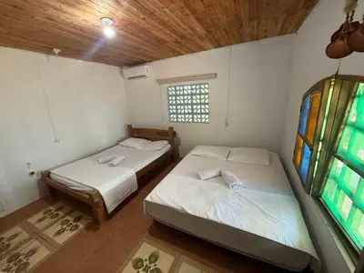 two beds in a room with a window at Espectacular cabaña frente al mar in Paso Nuevo