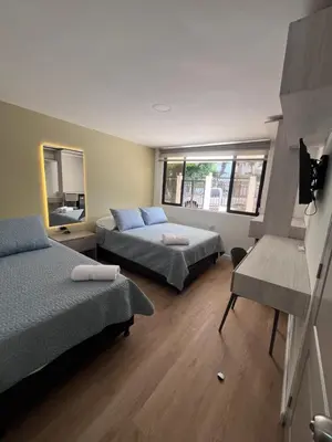 a bedroom with two beds and a window at Loft Deluxe - Nuevo, Acogedor, Integral, Ubicación inmejorable in Barranquilla