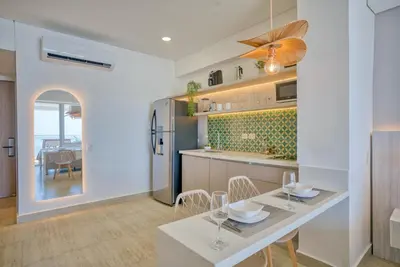 a kitchen and dining room with a table and chairs at Beachfront Studio with Stunning Ocean Views in Cartagena de Indias
