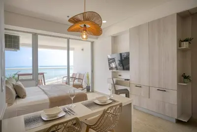 a bedroom with a bed and a table with chairs at Beachfront Studio with Stunning Ocean Views in Cartagena de Indias