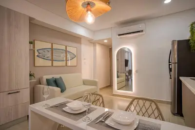 a kitchen and living room with a table and a couch at Beachfront Studio with Stunning Ocean Views in Cartagena de Indias